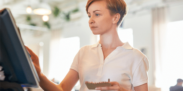 Restaurant staff member entering an order on a POS terminal.